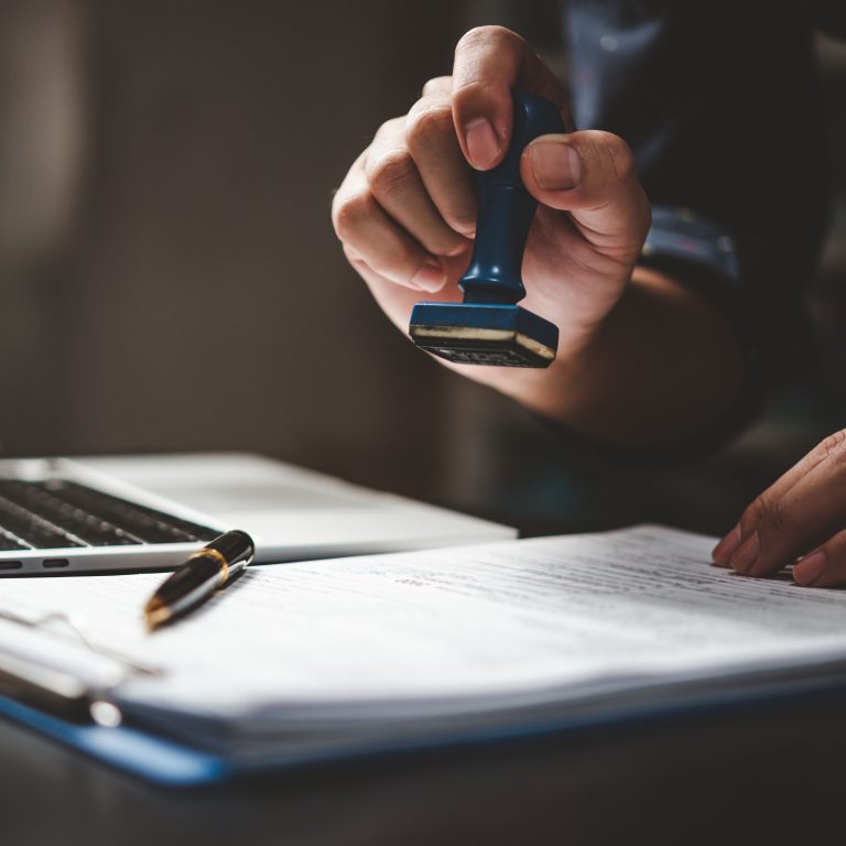 Man stamping approval of work finance banking or investment marketing documents on desk